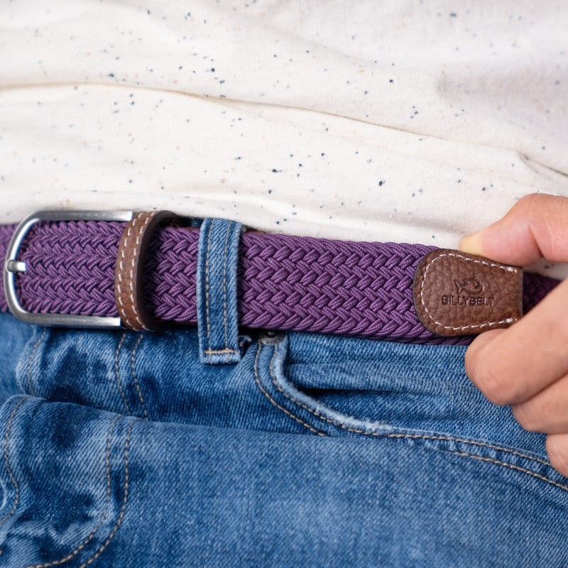 Plum woven belt with brown buckle being worn on blue jeans.